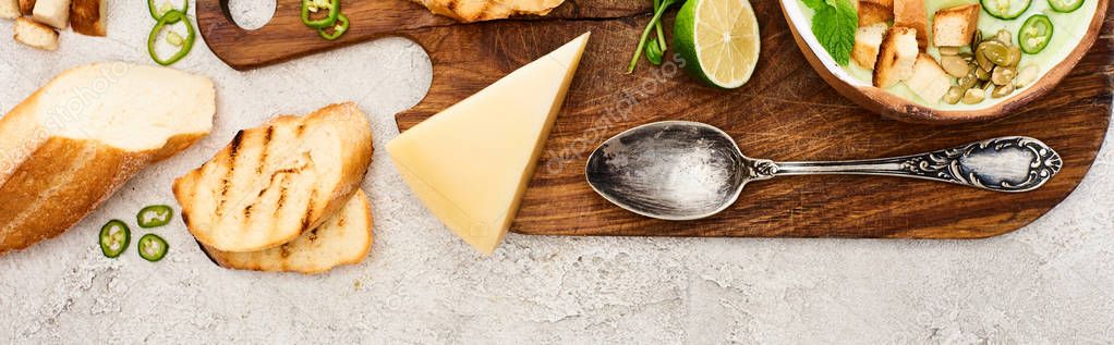 Panoramic shot of green vegetable creamy soup on wooden chopping board on textured surface — Stock Image Panoramic Shot Green Vegetable Creamy Soup Wooden Chopping Board Textured Stock Photo