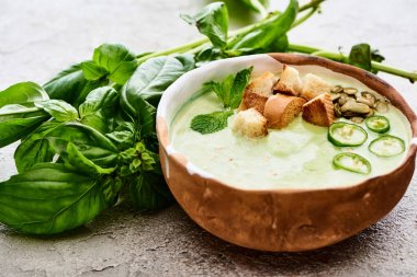 bowl of delicious green spinach creamy soup with croutons, jalapenos and pumpkin seeds clipart