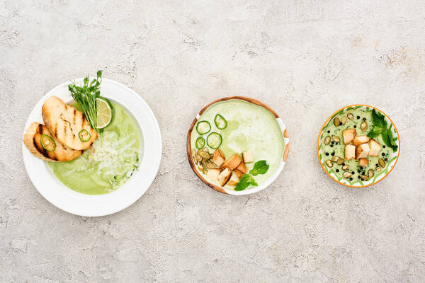 flat lay with delicious creamy green soup served with croutons