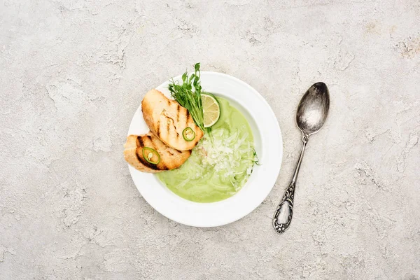 Top view of delicious creamy green vegetable soup with croutons served with spoon — Stock Image Top View Delicious Creamy Green Vegetable Soup Croutons Served Spoon Stock Image