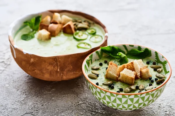 Bowls of tasty green vegetable creamy soup with croutons, jalapenos, black pepper and pumpkin seeds — Stock Image Bowls Tasty Green Vegetable Creamy Soup Croutons Jalapenos Black Pepper Stock Image