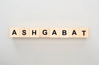 top view of wooden blocks with Ashgabat lettering on grey background clipart