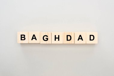 top view of wooden blocks with Baghdad lettering on grey background clipart