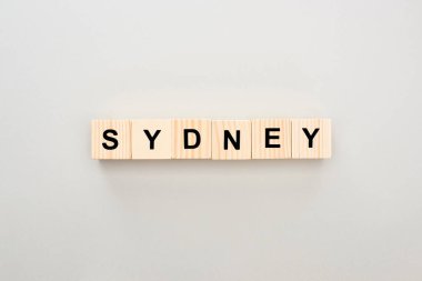 top view of wooden blocks with Sydney lettering on grey background clipart