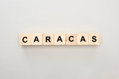 top view of wooden blocks with Caracas lettering on grey background clipart