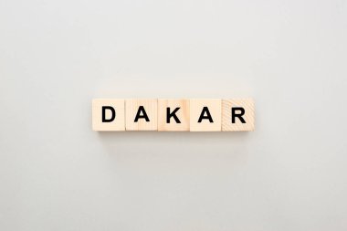 top view of wooden blocks with Dakar lettering on grey background clipart