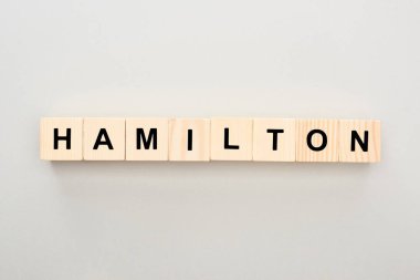 top view of wooden blocks with Hamilton lettering on grey background clipart