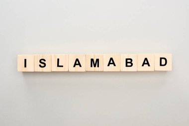 top view of wooden blocks with Islamabad lettering on grey background clipart