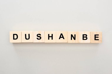 top view of wooden blocks with Dushanbe lettering on grey background clipart