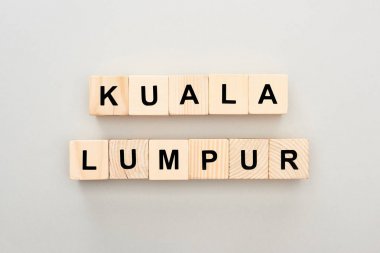 top view of wooden blocks with Kuala Lumpur lettering on grey background clipart