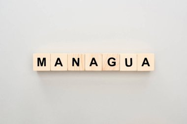 top view of wooden blocks with Managua lettering on grey background clipart