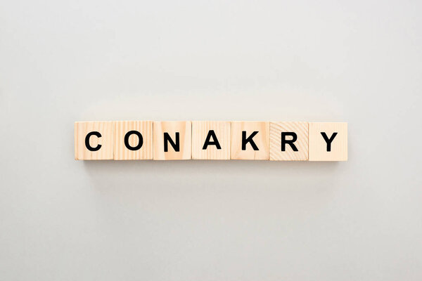 top view of wooden blocks with Conakry lettering on grey background