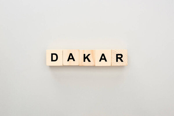 top view of wooden blocks with Dakar lettering on grey background