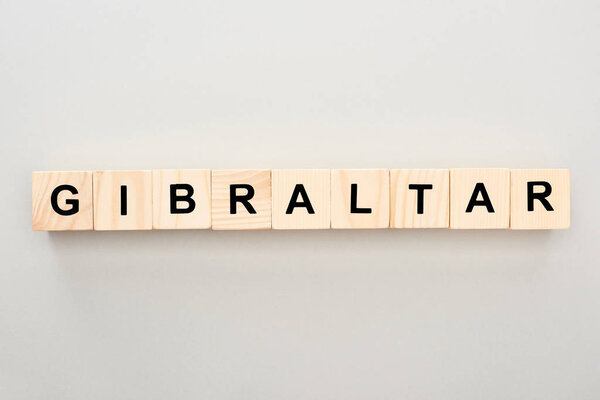 вид сверху на деревянные блоки с надписью Гибралтар на сером фоне

