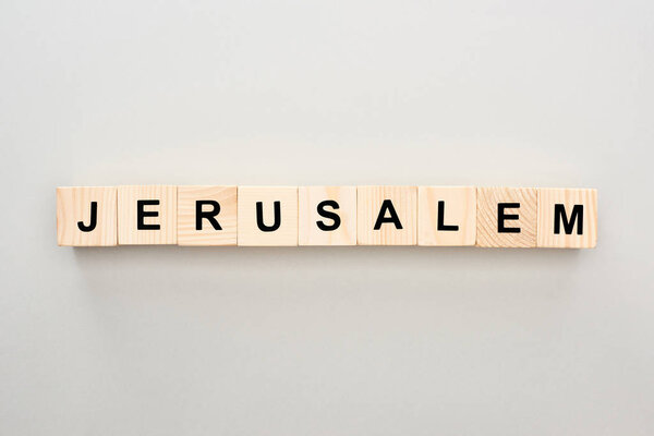 вид сверху на деревянные блоки с иерусалимской надписью на сером фоне
