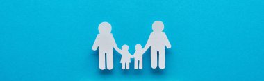 panoramic shot of paper cut family holding hands on blue background clipart