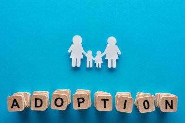 mavi arka plan üzerinde kağıt kesim lezbiyen aile yakın benimseyen harflerle ahşap blokların üst görünümü