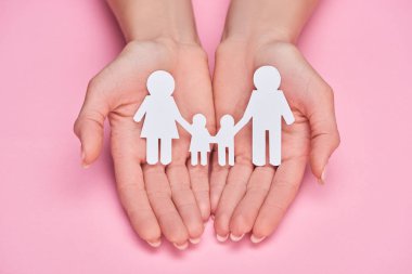 pembe arka plan üzerinde kağıt kesim aile tutan kadın kırpılmış görünümü