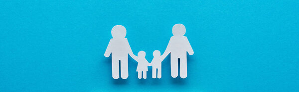 panoramic shot of paper cut family holding hands on blue background