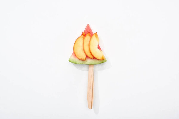 top view of delicious watermelon on stick with nectarine on white background