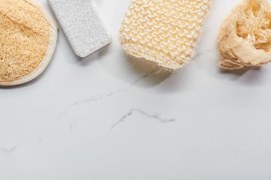 mermer yüzeyinde pomza taşı, loofah ve banyo süngerlerinin üst görünümü