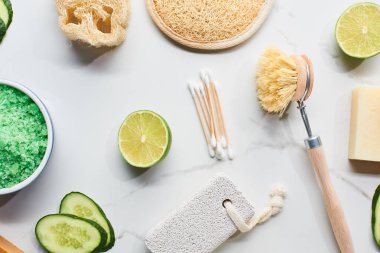 mermer yüzeyinde taze kireç ve salatalık yakın yeşil banyo tuzları, vücut fırçası, loofah, banyo süngeri ve pomza taşı üst görünümü