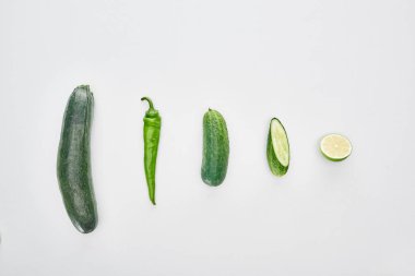 top view of fresh and green cucumbers, lime, pepper and zucchini clipart