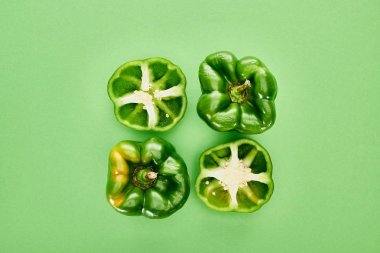 top view of fresh and organic peppers on green background  clipart