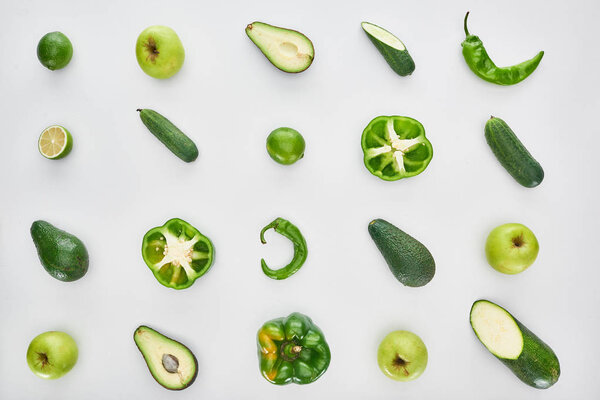 top view of green apples, avocados, cucumbers, kiwi, limes, peppers and zucchini