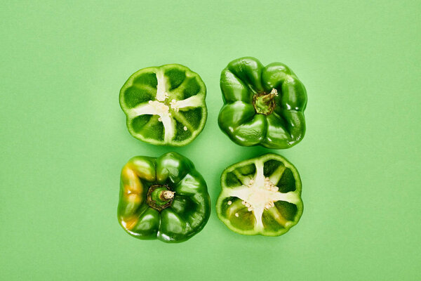 top view of fresh and organic peppers on green background 