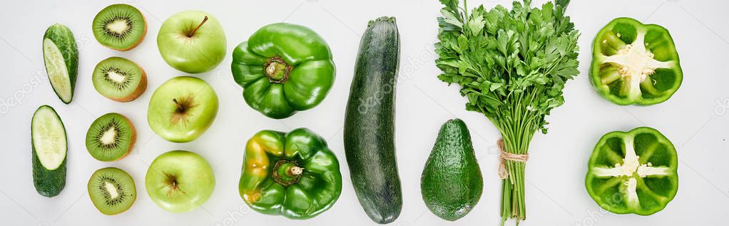 panoramic shot of peppers, cucumbers, zucchini, kiwi, apples, greenery and avocado