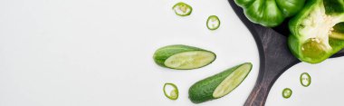 panoramic shot of peppers and cucumbers on wooden pizza skillet clipart