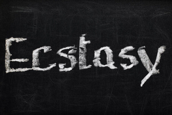 вид сверху на черную доску с надписью экстаз
