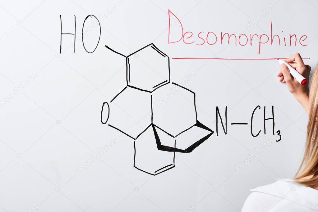 cropped view of woman writing desomorphine on white board 