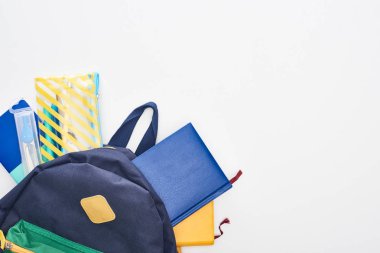 Not defterleri, kalem kutusu ve beyaz izole okul malzemeleri ile Mavi okul çantası 