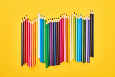 Sharpened color pencils isolated on yellow clipart