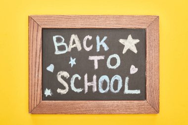Sarı arka plan üzerinde küçük yıldızlar ve kalpler ile okul yazıt geri ahşap çerçeve içinde Chalkboard
