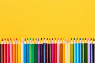 Bright color sharpened pencils isolated on yellow clipart