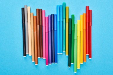 Set of bright colored felt-tip pens isolated on blue clipart