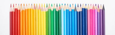 Panoramic shot of rainbow spectrum made with straight row of color pencils isolated on white clipart