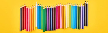 Panoramic shot of color pencils set isolated on yellow clipart