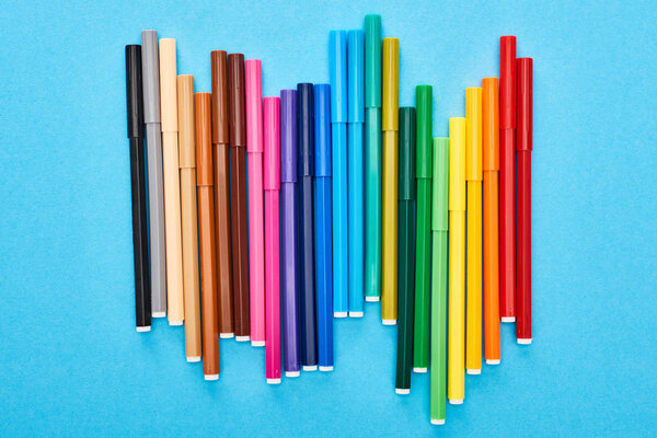 Set of bright colored felt-tip pens isolated on blue