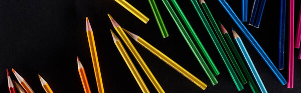 Панорамный снимок радужного градиента, выполненный цветными карандашами, изолированными на черном
