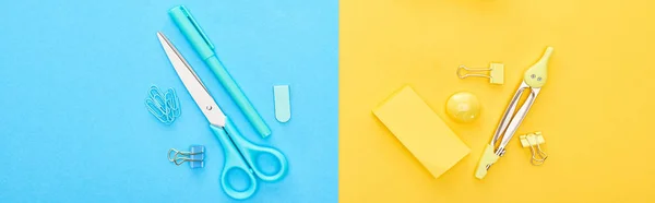 バイカラーの背景に異なる青と黄色の文房具のパノラマショット — ストック写真