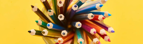 Panoramic shot of sharpened and bright color pencils isolated on yellow