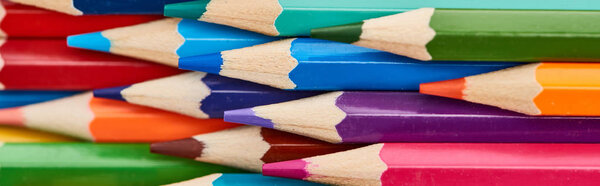 Panoramic shot of color wooden pencils with sharpened ends