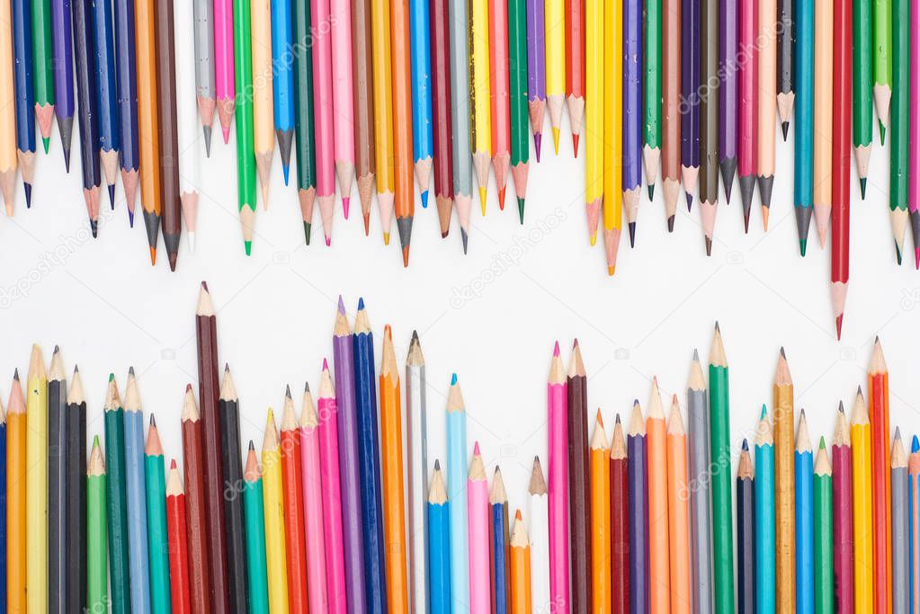 Two lines of different sizes color pencils isolated on white