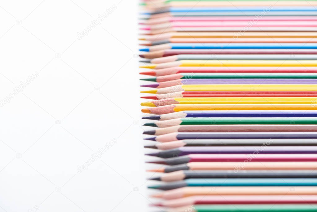 Straight row of sharpened color pencils isolated on white