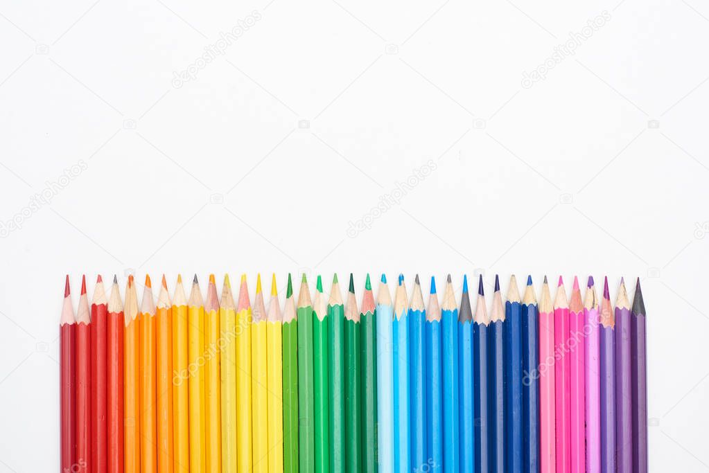 Rainbow spectrum made with straight row of color pencils isolated on white
