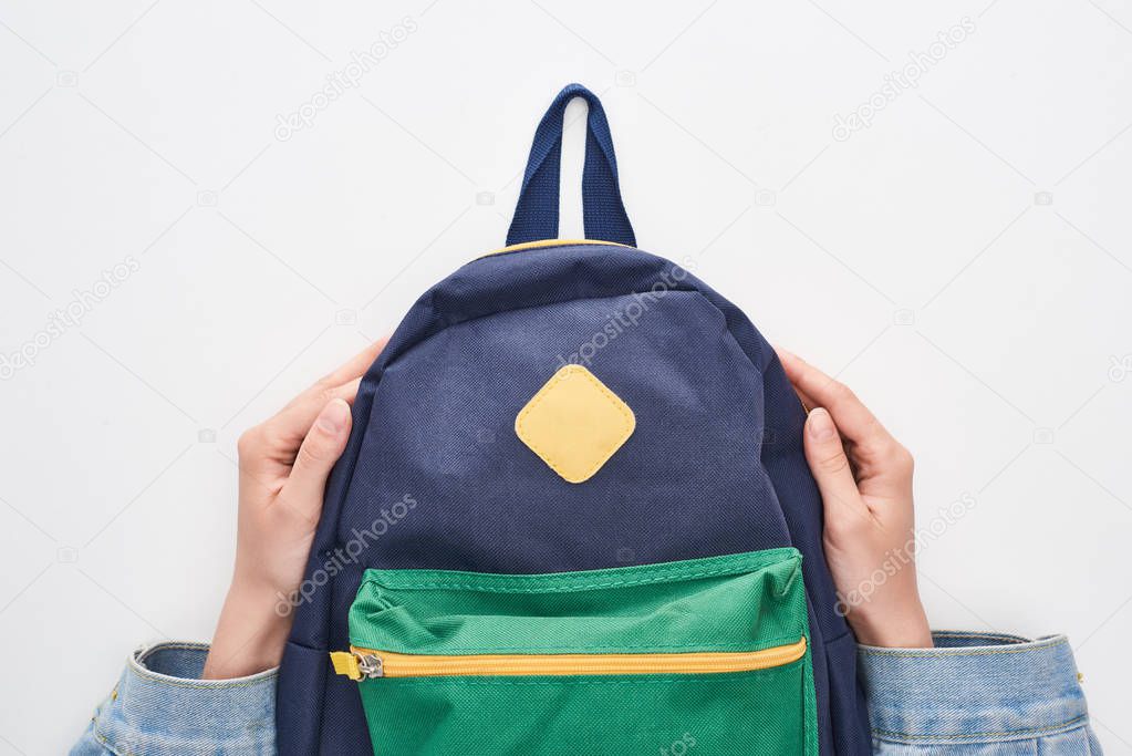 Schoolgirl holding blue schoolbag with green pocket isolated on white